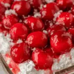 Close-up of Cherries in the Snow dessert with bright red cherries and fluffy whipped cream topping.