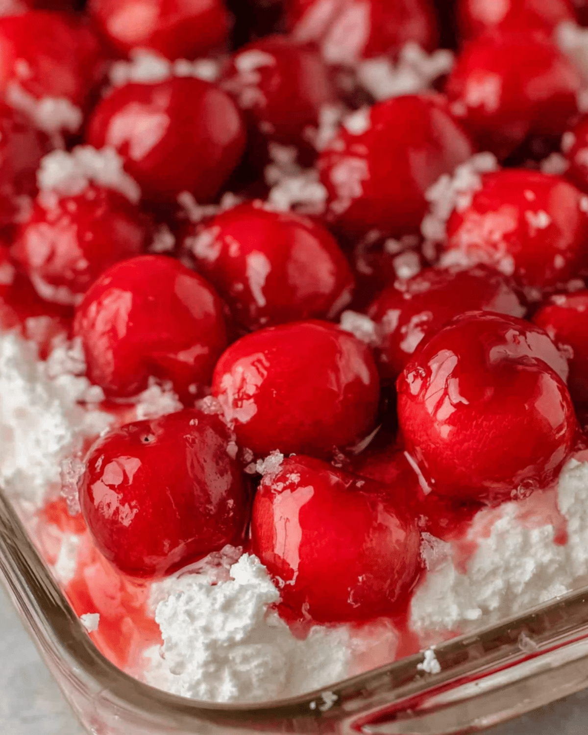 Close-up of Cherries in the Snow dessert with bright red cherries and fluffy whipped cream topping.