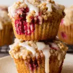 Stack of two Cranberry Orange Muffins with crumb topping and icing drizzle