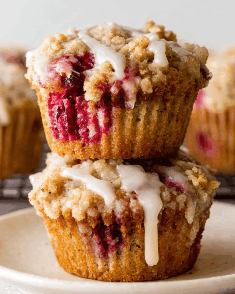 Stack of two Cranberry Orange Muffins with crumb topping and icing drizzle
