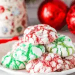 Plate of festive crinkle cookies in red and green colors, dusted with powdered sugar.