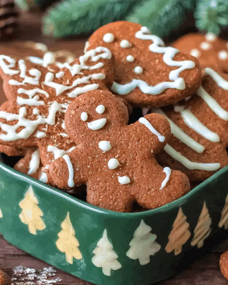 A festive assortment of German gingerbread cookies decorated with white icing in a green holiday-themed tin.