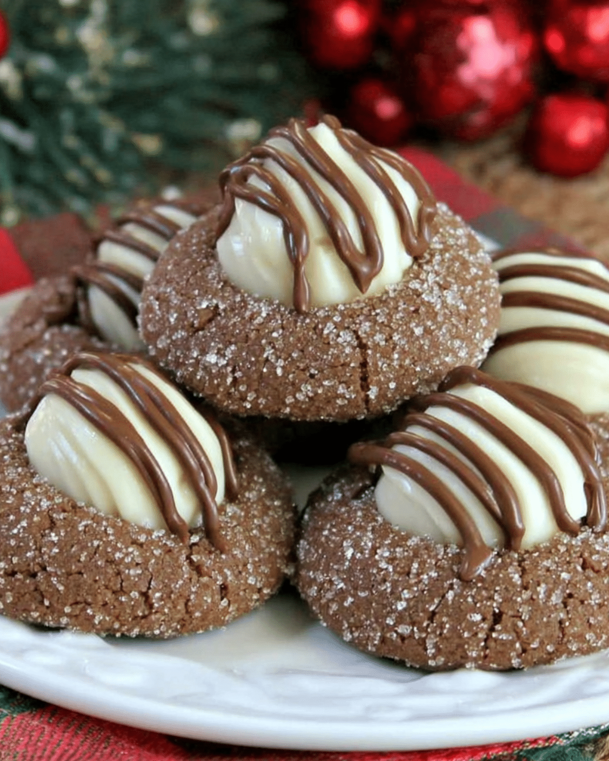 Plate of Gingerbread Kiss Cookies topped with white chocolate kisses and drizzled with milk chocolate.
