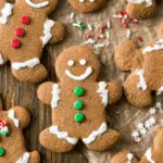 Assorted Gingerbread Men Cookies decorated with icing and colorful candy on a wooden surface.