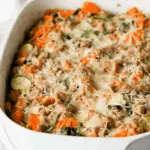Baked casserole dish filled with Ground Turkey Sweet Potato Bake topped with melted cheese and herbs.
