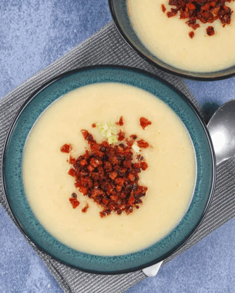 Bowls of Leek, Butter Bean & Crispy Chorizo Soup topped with finely chopped chorizo and garnished with green onion.