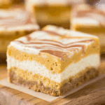 Close-up of a Pumpkin Spice Cheesecake Bar with layers of graham cracker crust, creamy cheesecake, and pumpkin spice topping.