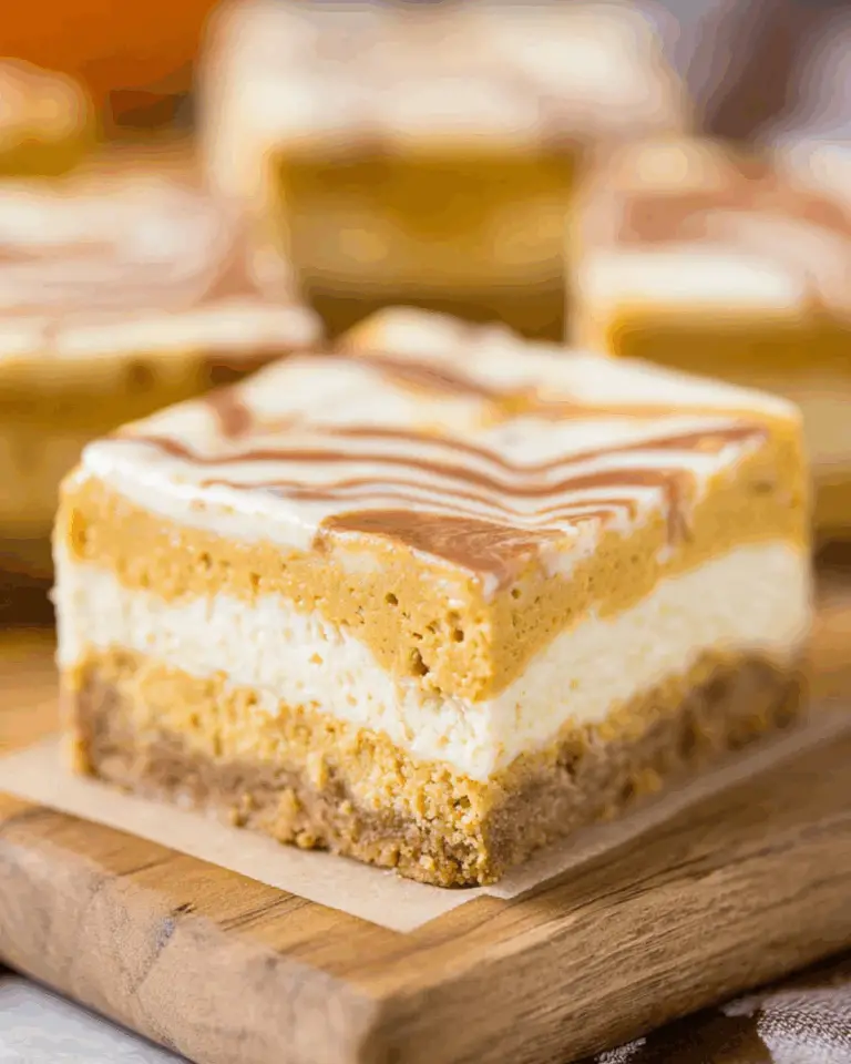 Close-up of a Pumpkin Spice Cheesecake Bar with layers of graham cracker crust, creamy cheesecake, and pumpkin spice topping.