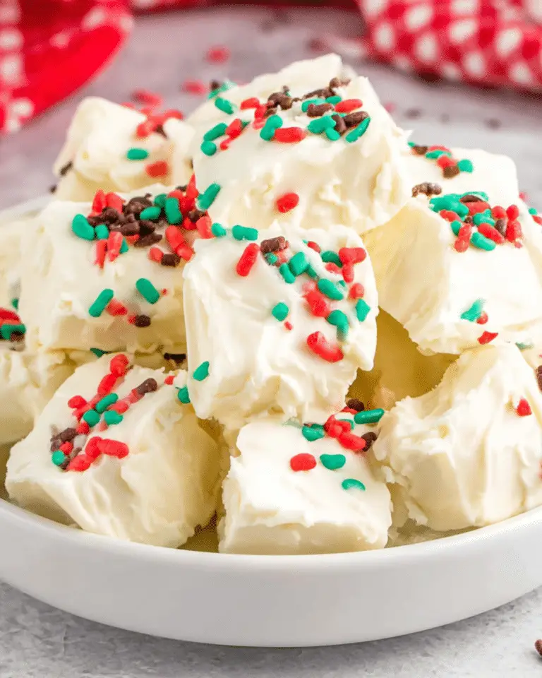 A bowl filled with white Cool Whip candy squares topped with festive red, green, and brown sprinkles.